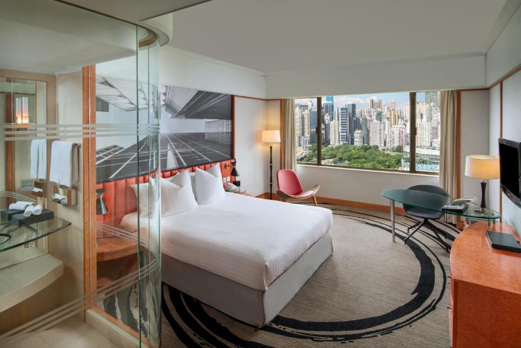 una camera d'albergo con un letto e una grande finestra di The Park Lane Hong Kong, Autograph Collection a Hong Kong