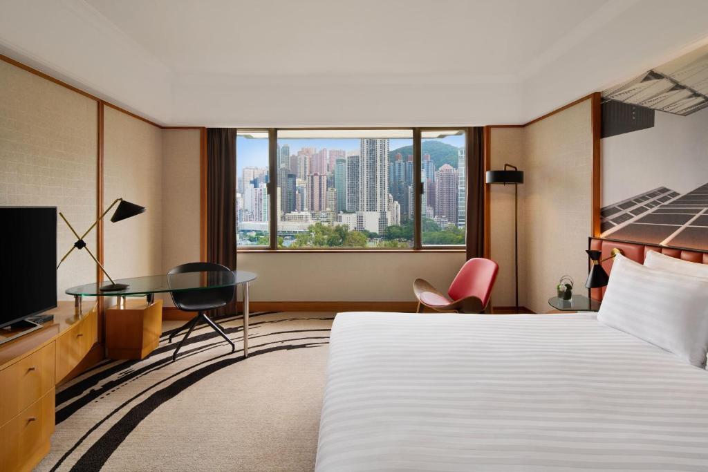 una camera d'albergo con un letto, una scrivania e una finestra di The Park Lane Hong Kong, Autograph Collection a Hong Kong