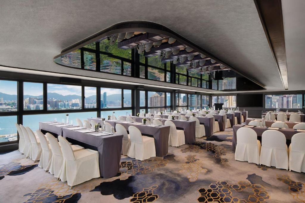 una sala banchetti con sedie e tavoli bianchi e finestre di The Park Lane Hong Kong, Autograph Collection a Hong Kong