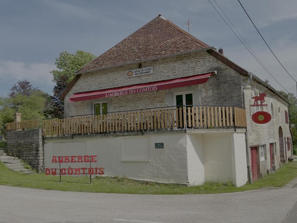 an old building with a balcony on the side of it at Auberge du Comtois in Pont-dʼHéry
