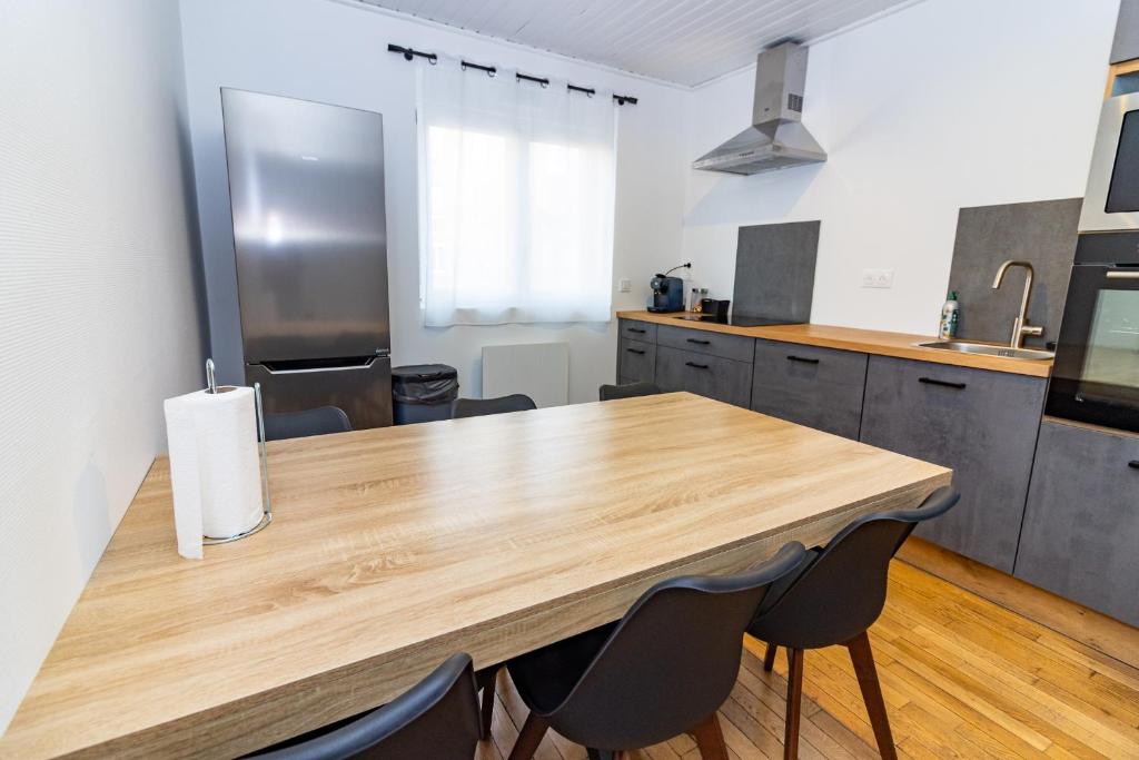 une cuisine avec une table et des chaises en bois dans l'établissement Belle Maison Nancy avec 3 chambres individuelles, à Nancy