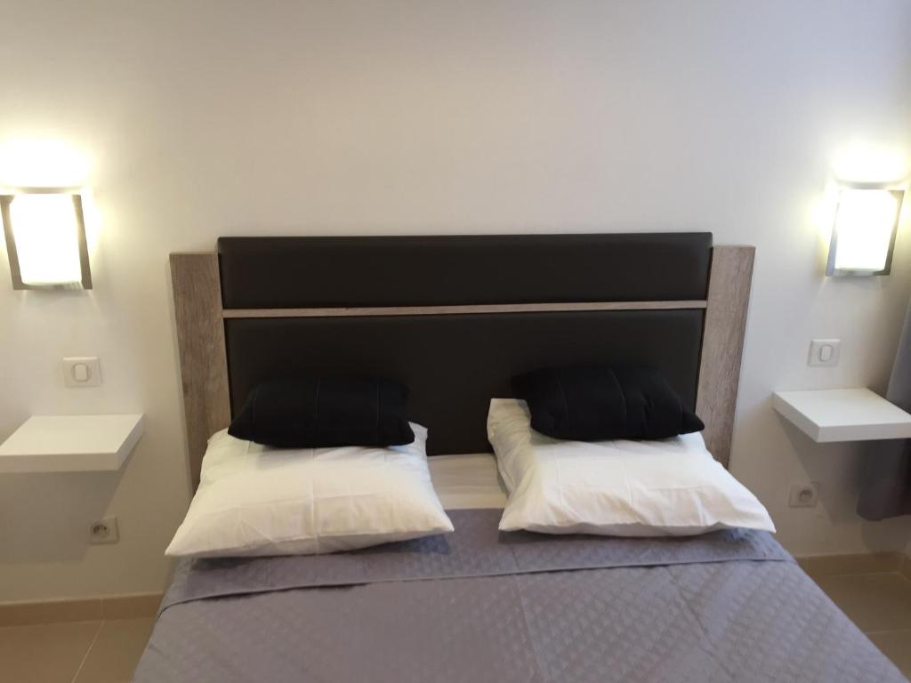 a bedroom with a bed with two pillows on it at Appartement Le Vieux Port in Marseille