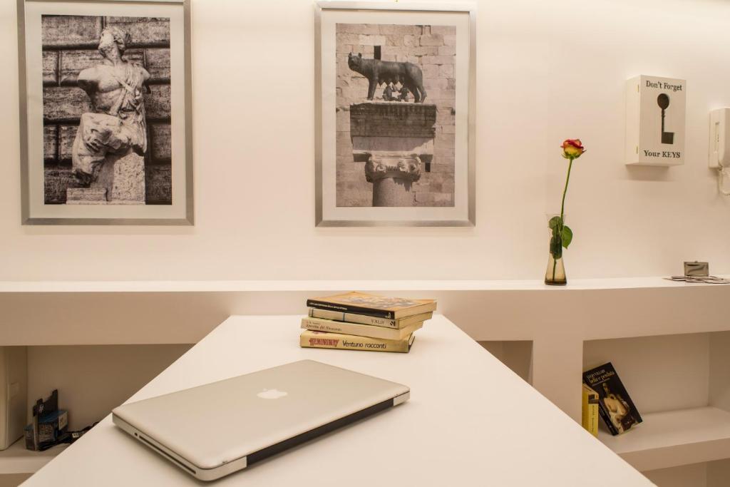 a laptop computer sitting on a table with books at Mirabilia Urbis Roma in Rome