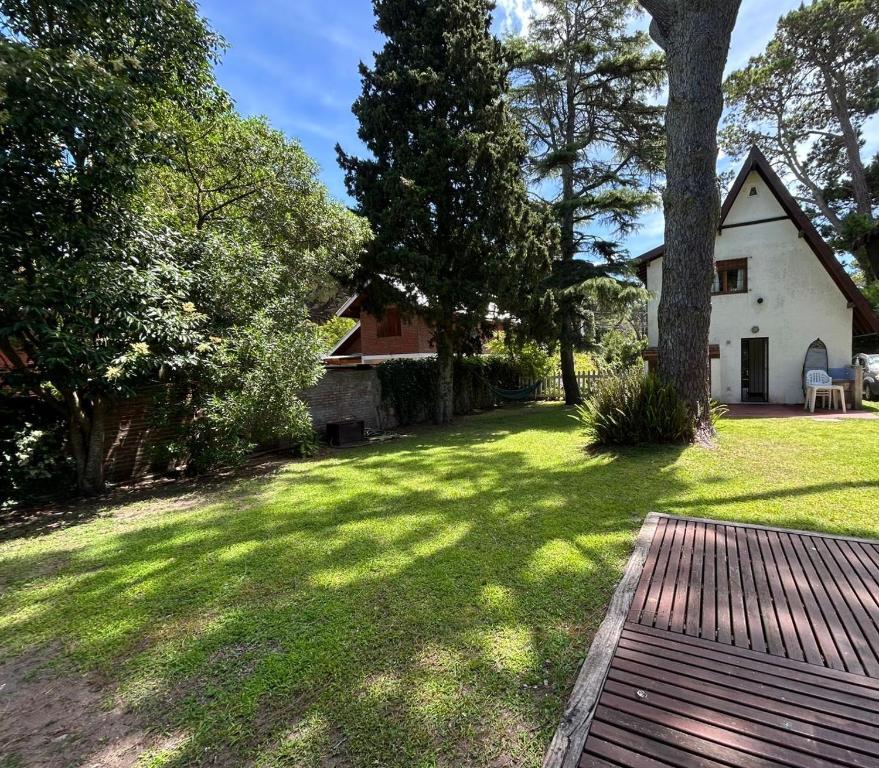 ein Hof mit einem Baum und einem Haus in der Unterkunft Makikihi - Barrio Norte in Villa Gesell