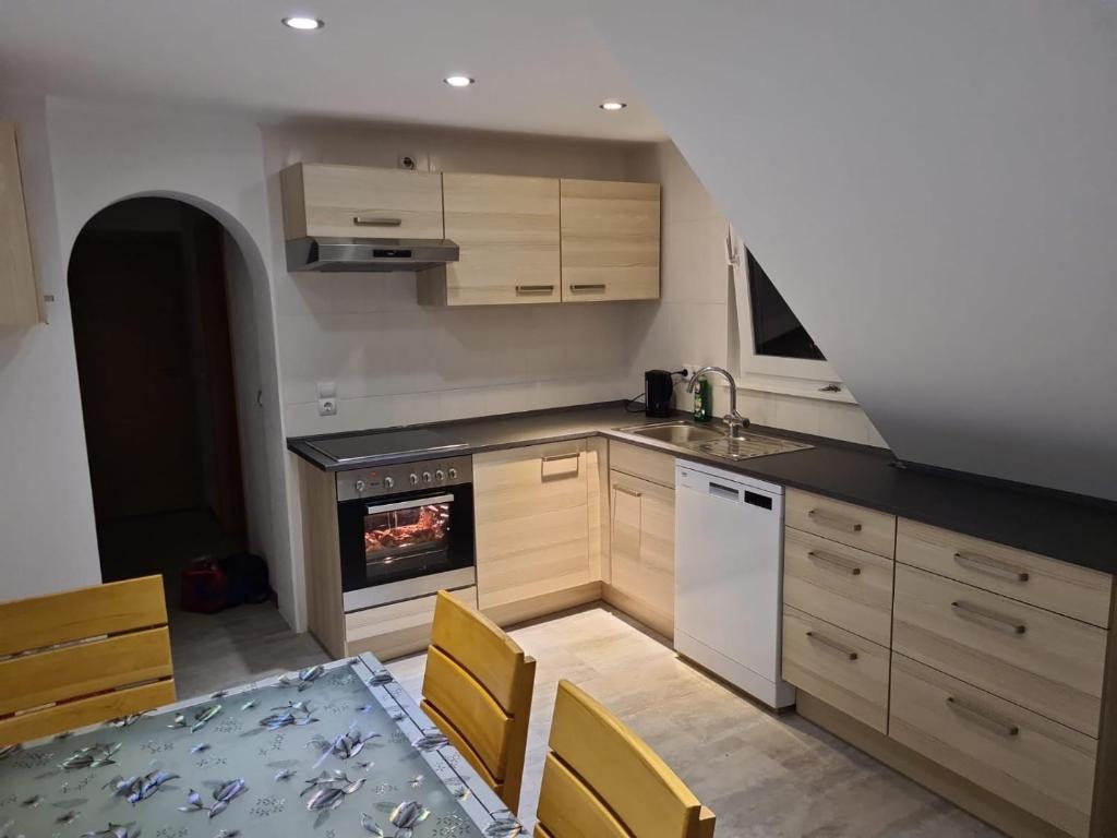 a kitchen with a stove and a table with chairs at KRAICHGAU # 3-ZKB mit 100qm voll ausgestattet im DG, Monteurzimmer, Self-Check-in in Ittlingen