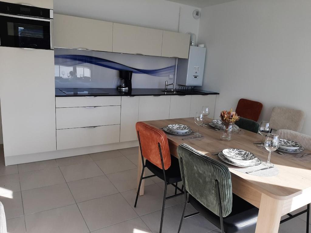 une cuisine avec une table et des chaises en bois dans l'établissement La Poulouchette Berck appartement 200m de la plage, à Berck-sur-Mer