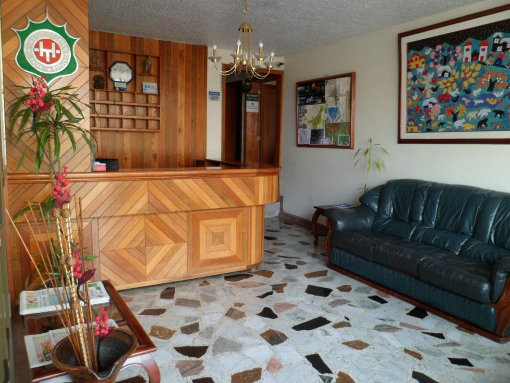 a living room with a couch and a table at Hotel Tuvalu in Paipa
