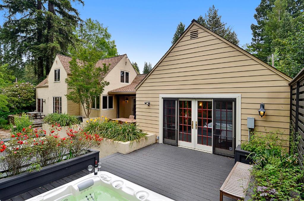 a house with a wooden deck with a hot tub at Villa Tranquila in Guerneville