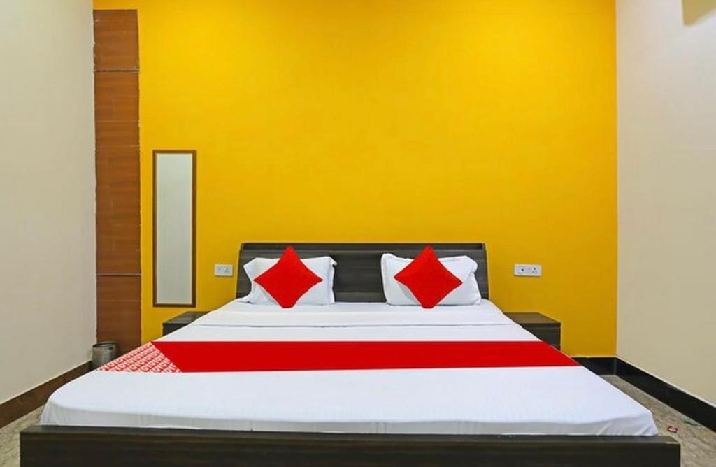 坎普尔Hotel Mannu Grand的卧室里有一张大床，配有红色枕头