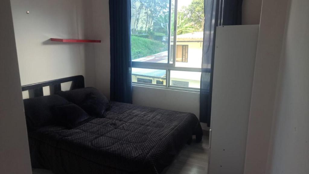 a bedroom with a bed and a large window at Apartamento en La Colina in Macanal
