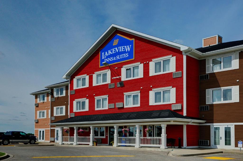 um edifício vermelho com uma placa para um hotel em Lakeview Inns & Suites - Brandon em Brandon