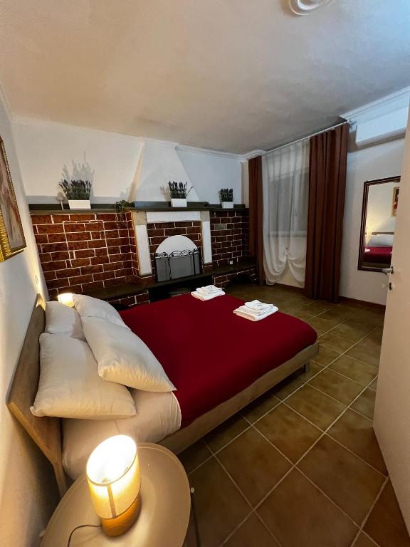 a large bed in a room with a brick wall at Spacious Apartments - 5 min Ciampino airport by car -sleeps 6 - Easy Train to Rome- LA MAISON in Ciampino