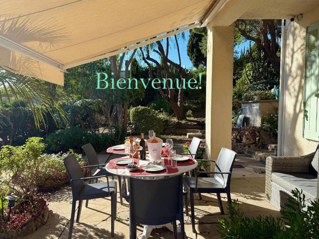 - une table et des chaises sur une terrasse avec un panneau indiquant la bière maison dans l'établissement Authentique Villa le Cactus entièrement rénovée climatisée proche des plages du centre du Lavandou et du supermarché, à Bormes-les-Mimosas