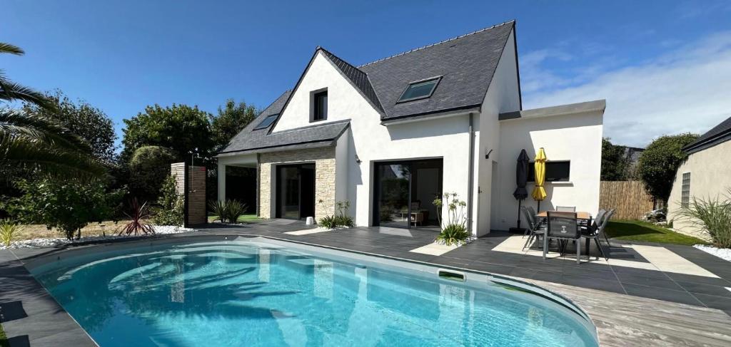 une maison avec une piscine devant une maison dans l'établissement TY HEOL • la maison du soleil•, à Saint-Pierre-Quiberon