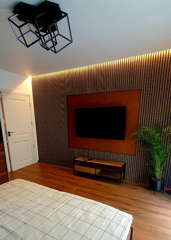 a living room with a flat screen tv on a wall at Central One Guesthouse in Reşiţa