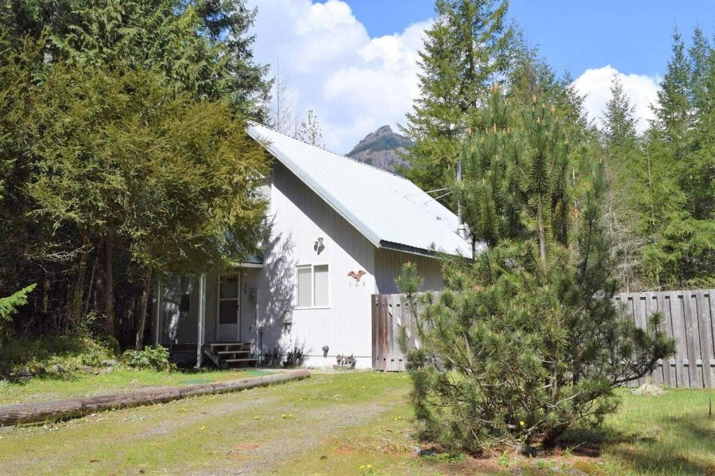 una casa blanca con una valla y un patio en Butter Creek Cabin, en Packwood