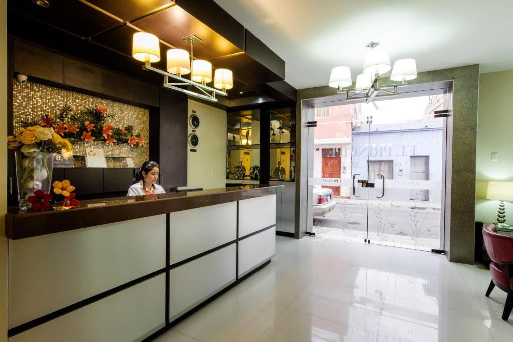 a woman sitting at a counter in a restaurant at El Principe Hoteles in Piura