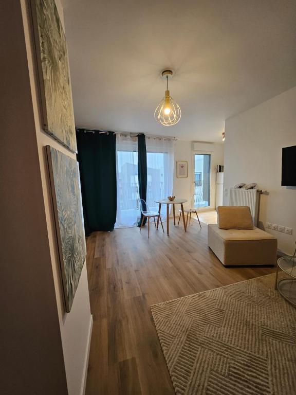 un salon avec un canapé et une table dans l'établissement Appart 10 min Euro Disney - Bussy Saint Georges, à Bussy-Saint-Georges