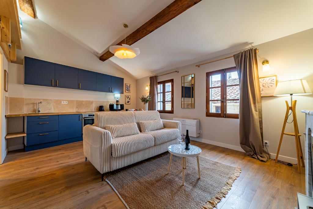 a living room with a couch and a table at Duplex Caché Toits & Tradition in Sommières