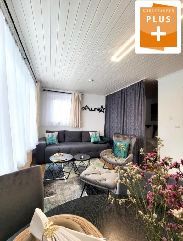 a living room with a couch and chairs and flowers at Ferienwohnung Alpinstar - inklusive Oberstaufen Plus in Oberstaufen