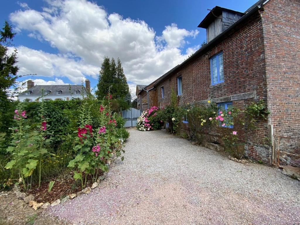 un bâtiment en briques avec des fleurs sur son côté dans l'établissement The Coach House, à Saint-Aubin-de-Bonneval