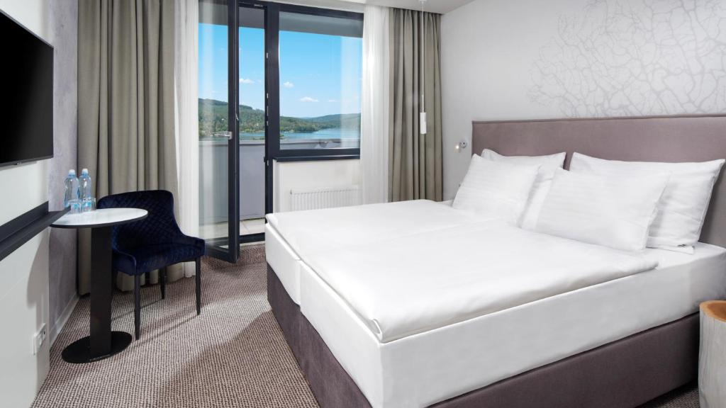 布尔诺OREA Resort Santon Brno的一间带白色床和窗户的酒店房间