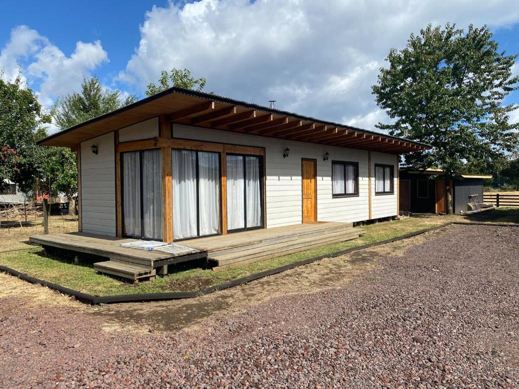 a small house with a porch on a gravel road at Cabaña M&R 2 in Lago Ranco