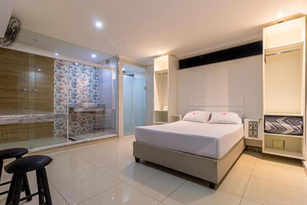 圣保罗Hotel Age - Próximo Arena Corinthians e Aeroporto de Guarulhos的卧室里有一张白色的床和一扇大窗户
