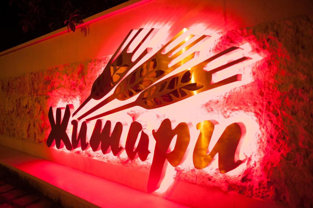 a neon sign on a wall with writing on it at Complex Jitari in Zhitnitsa