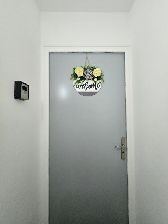 a door with a sign on it with flowers on it at Cosy appartement proche Disneyland in Étampes-sur-Marne