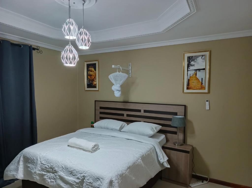 a bedroom with a bed with two towels on it at Semuya Apartments in Ndola