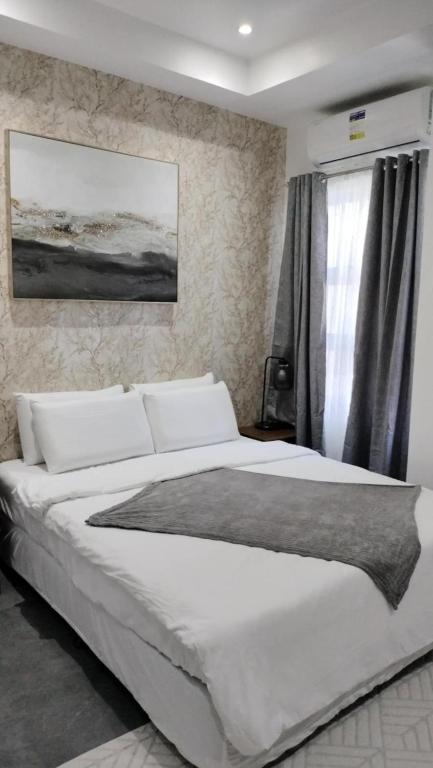 Un dormitorio con una gran cama blanca y una ventana. en Mactan Reihenhaeuser, en Lapu Lapu City