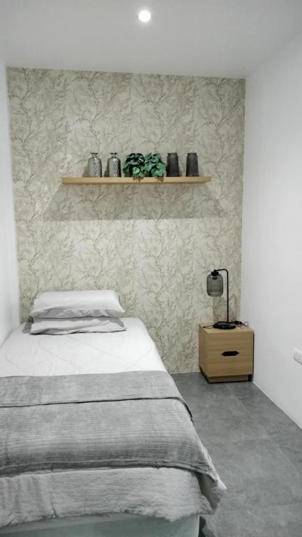 1 dormitorio con cama y estante en la pared en Mactan Reihenhaeuser, en Lapu Lapu City