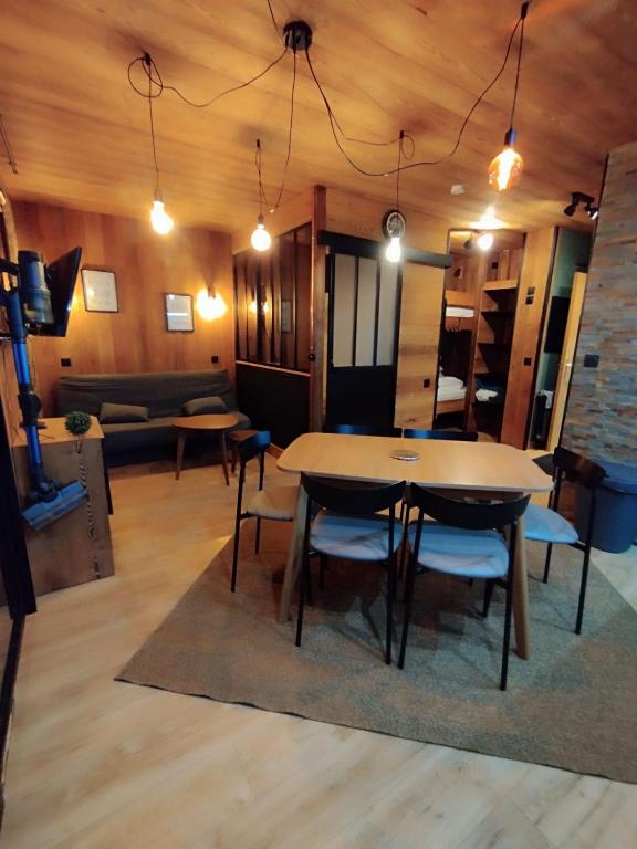 une salle à manger avec une table, des chaises et un canapé dans l'établissement Appartement les Orres 1800, aux Orres