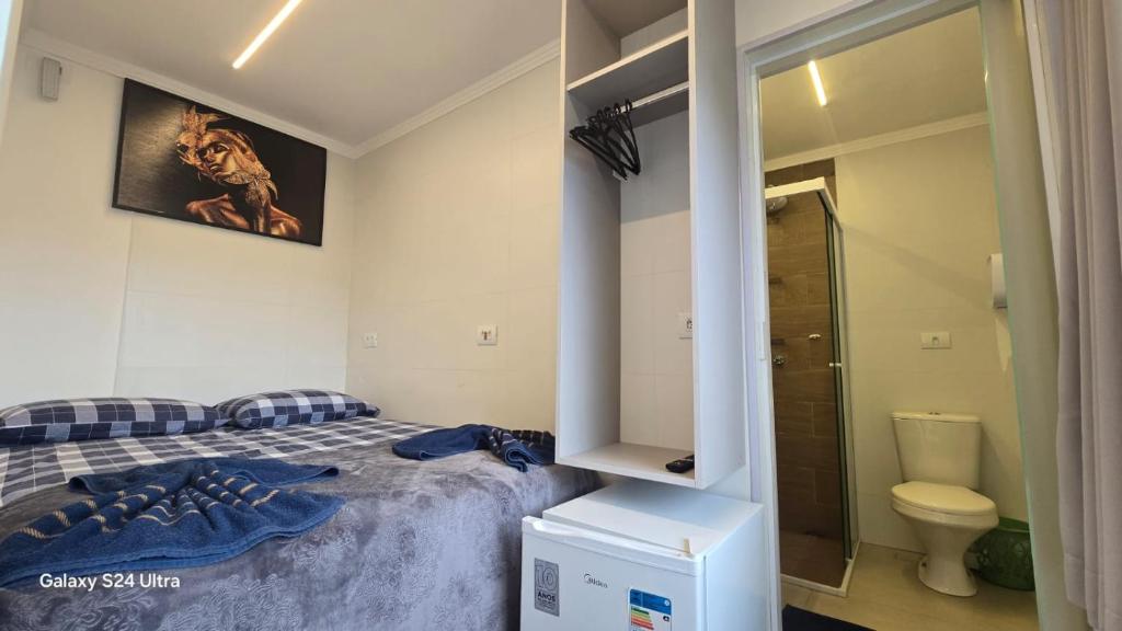 Un dormitorio pequeño con una cama y un baño. en CASA HOTEL PIRACICABA, en Piracicaba