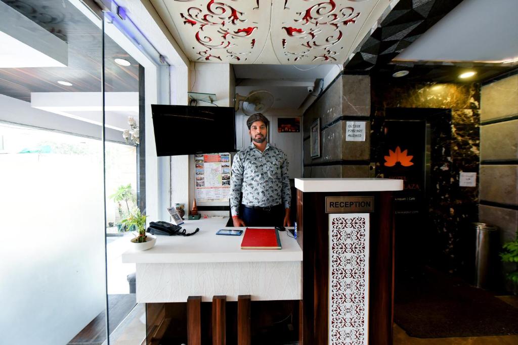 a man standing behind a counter in a room at Collection O Tip Top in Jaipur