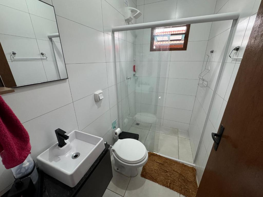 a bathroom with a toilet and a shower and a sink at Tanuri in Itapoa