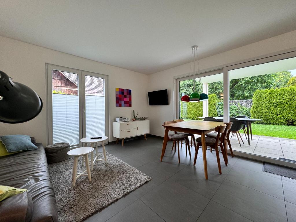 Una sala de estar con un sofá, una mesa y sillas. en See Raum, en Immenstaad am Bodensee