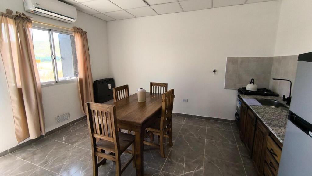 une cuisine avec une table et des chaises dans une pièce dans l'établissement Depto en planta baja muy comodo hasta 4 personas con Aire acondicionado, à Choele Choel