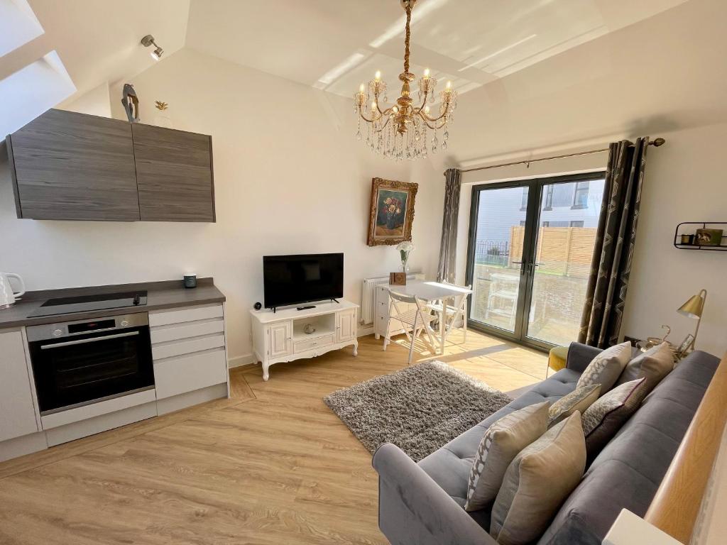 a living room with a couch and a tv at Salt Yard 1 - Stylish Whitstable Cottage - Free Parking - Beach - Harbour in Whitstable