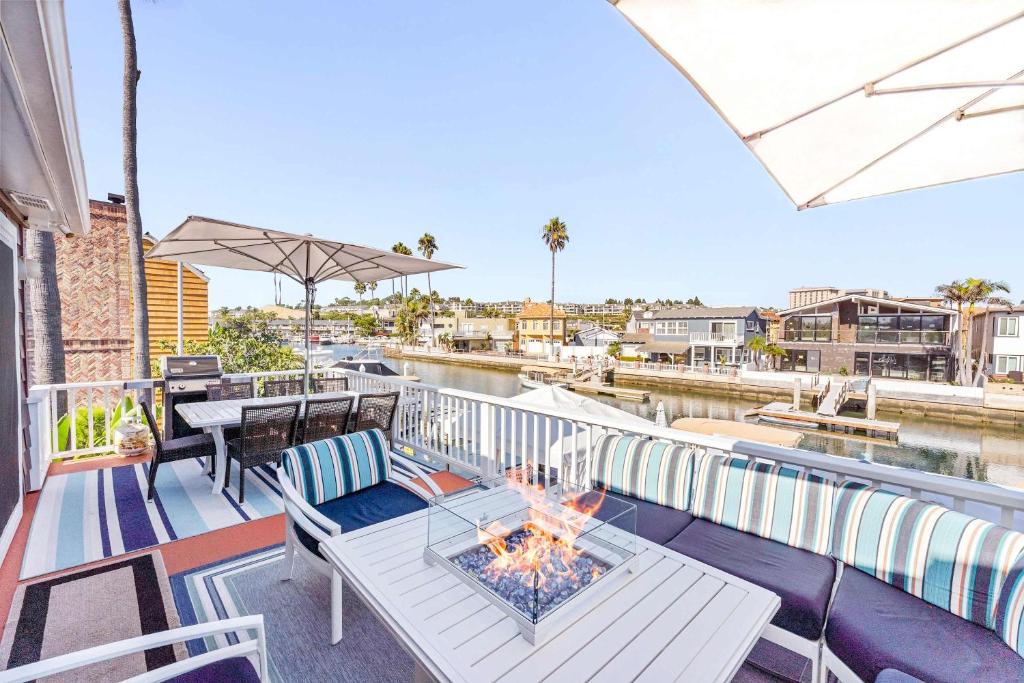 ein Balkon mit Tisch und Feuerstelle in der Unterkunft Stunning BayVIEW Home with Epic Waterfront Views! in Newport Beach
