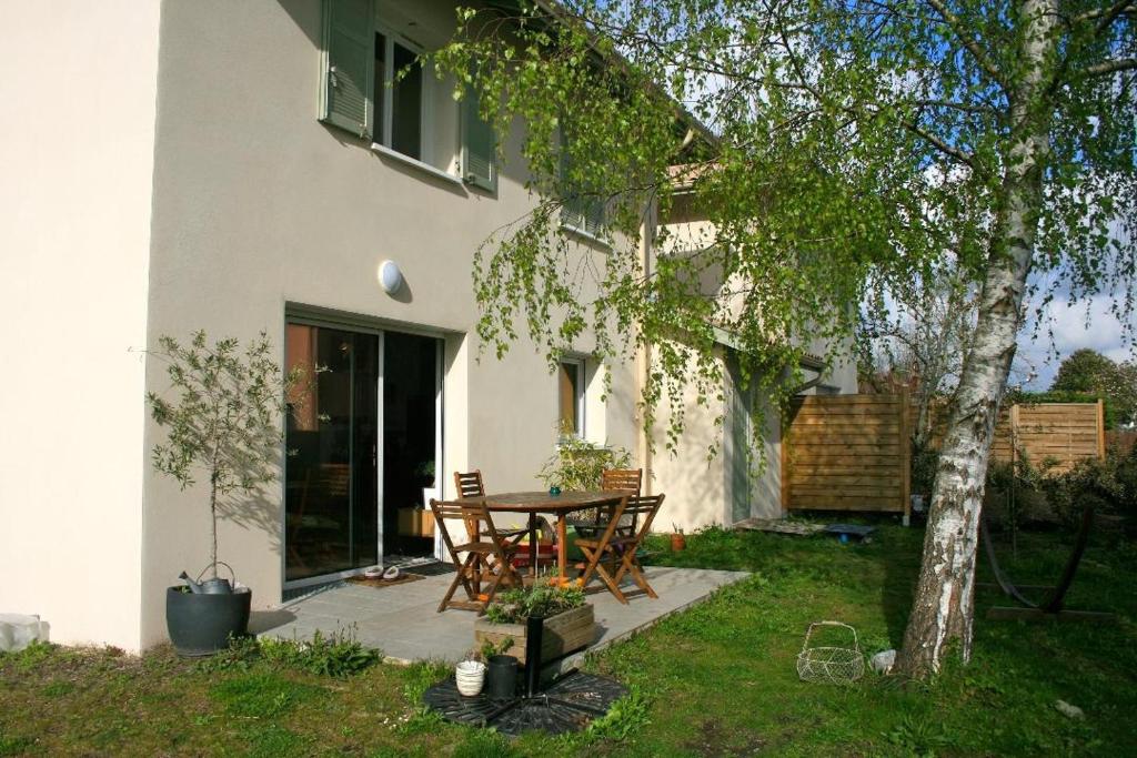 une terrasse avec une table et des chaises à côté d'une maison dans l'établissement La maison du Bonheur, à Bénesse-Maremne