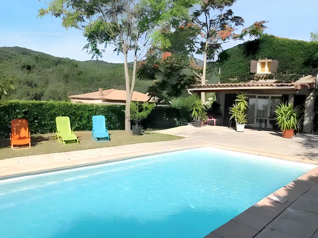 una piscina con due sedie e una casa di Villa spacieuse avec piscine à Rocher 180 m² 10 pers. a Rocher