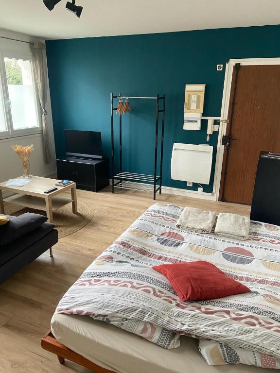 sypialnia z dużym łóżkiem i niebieską ścianą w obiekcie Dijon - Grand studio proche parc Darcy & gare w mieście Dijon