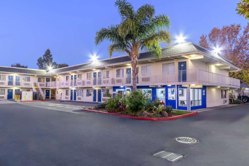 Un gran edificio con una palmera delante. en Motel 6 Hayward, CA- Silicon Valley Gateway, en Hayward