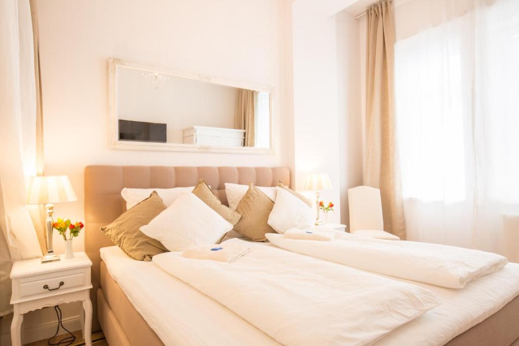 two white beds in a bedroom with a mirror at Apartment Fritz in Berlin