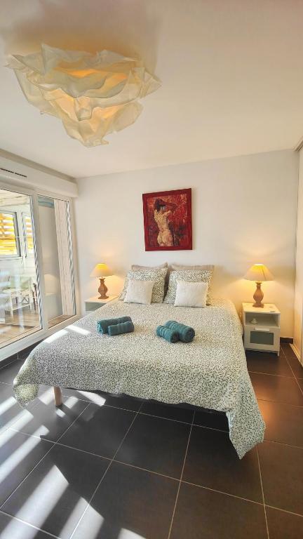 une chambre avec un grand lit avec deux lampes dans l'établissement Le Duplex Côté Vieux Port LA CIOTAT, à La Ciotat
