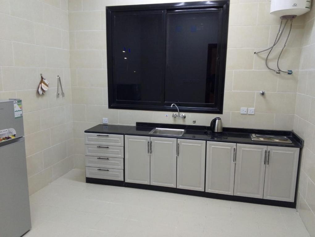 a bathroom with a sink and a large tv on the wall at الوعل للشقق الفندقية بالارطاوية in Al Arţāwīyah
