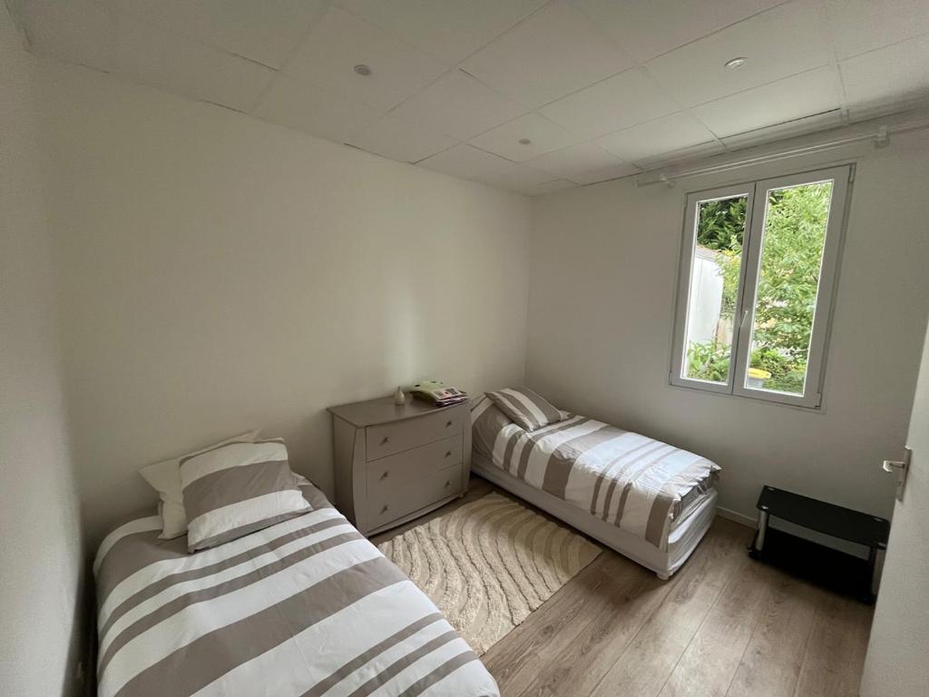 une chambre avec deux lits et une fenêtre dans l'établissement Quiet apartment area, à Vitry-sur-Seine