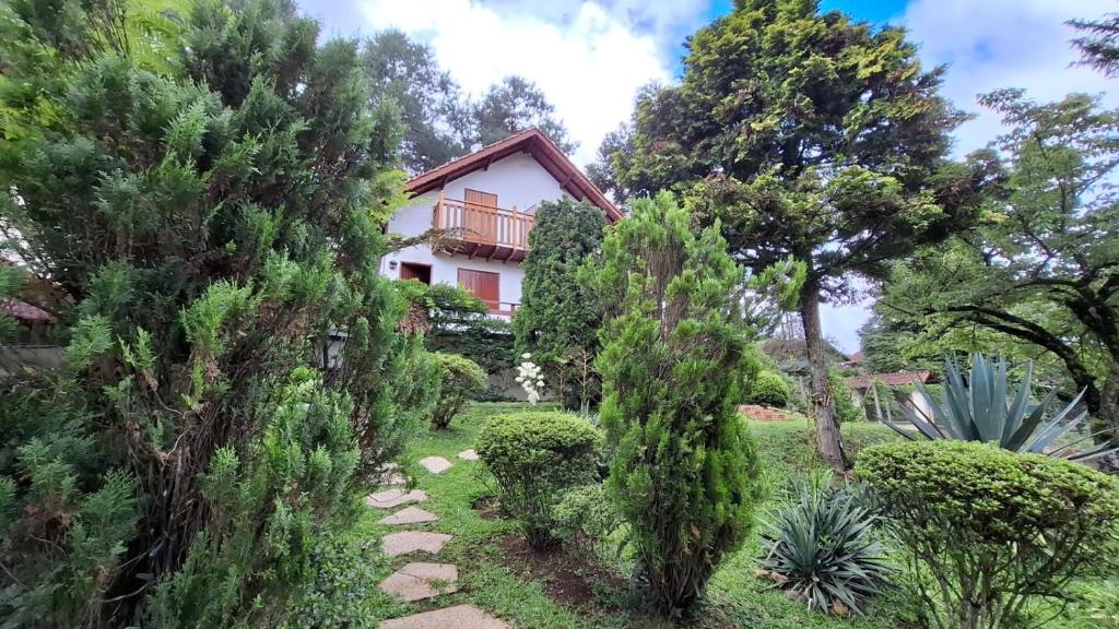 a house in the middle of a garden with trees at Chalés Lauterbrunnen in Monte Verde